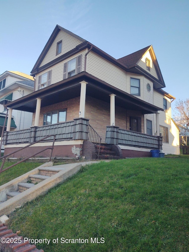 view of front of house with covered porch and a front lawn