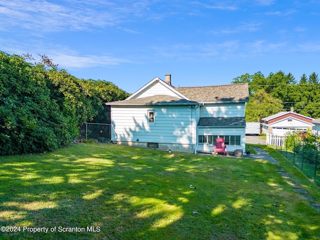 rear view of property featuring a lawn