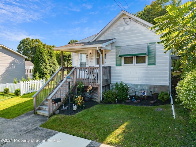 bungalow-style home with a front yard and covered porch