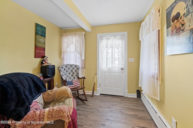 entryway featuring beamed ceiling, light wood-type flooring, and baseboard heating