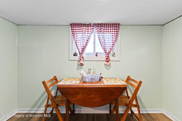 dining room featuring hardwood / wood-style flooring and wood walls