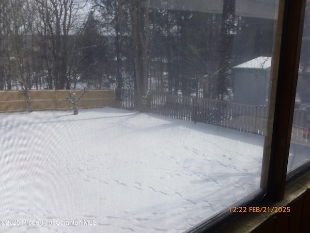 yard layered in snow featuring fence