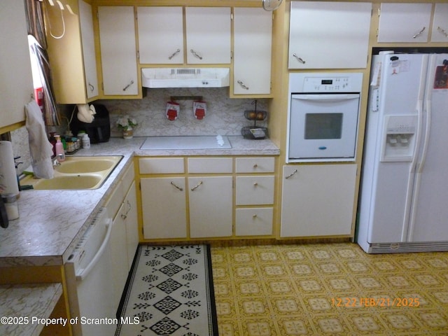 kitchen featuring light countertops, white cabinets, a sink, white appliances, and under cabinet range hood