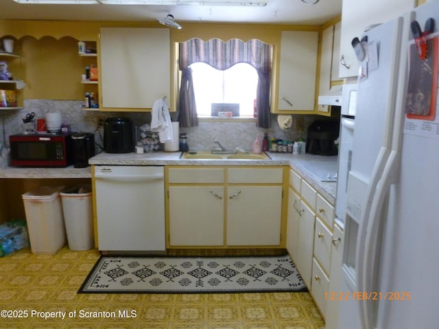 kitchen featuring white appliances, a sink, light countertops, open shelves, and backsplash