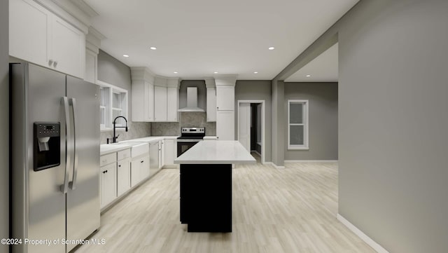 kitchen with sink, wall chimney range hood, tasteful backsplash, a kitchen island, and appliances with stainless steel finishes