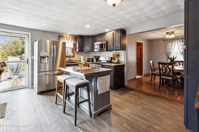 217 N Everett Ave, Scranton, PA 18504 - kitchen featuring dark brown cabinetry, wood finished floors, backsplash, and stainless steel appliances