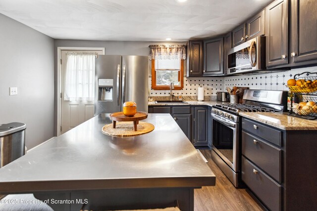 217 N Everett Ave, Scranton, PA 18504 - kitchen with tasteful backsplash, a sink, light wood-style floors, stainless steel appliances, and stainless steel counters