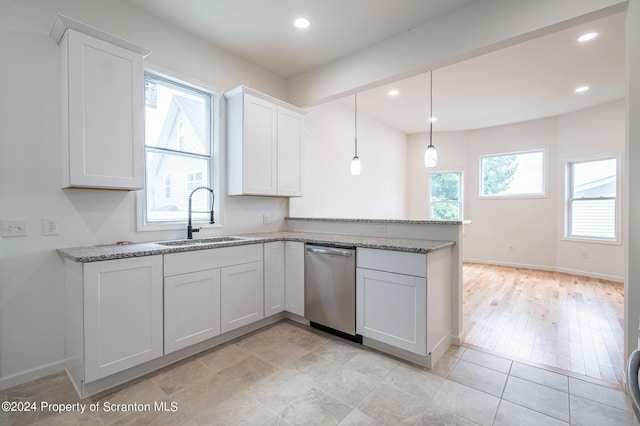 kitchen with sink, white cabinets, stainless steel dishwasher, and decorative light fixtures