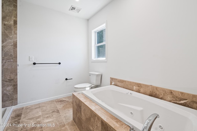 bathroom with toilet and tiled bath