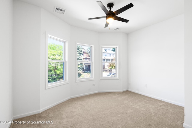 unfurnished room with ceiling fan and light carpet