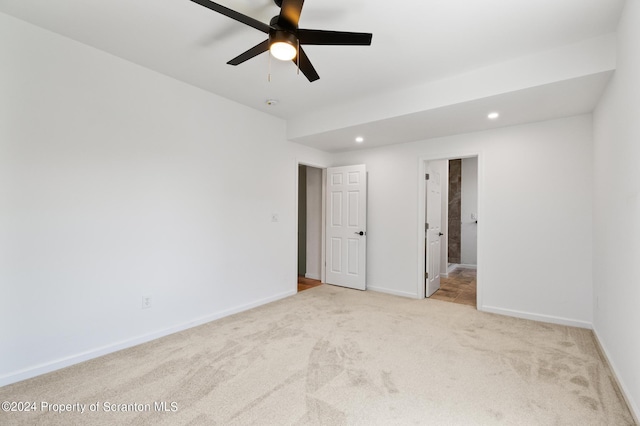 spare room featuring ceiling fan and light colored carpet