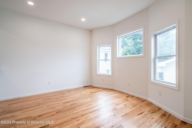 unfurnished room featuring light hardwood / wood-style floors and a wealth of natural light