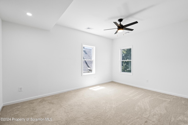 carpeted spare room featuring ceiling fan