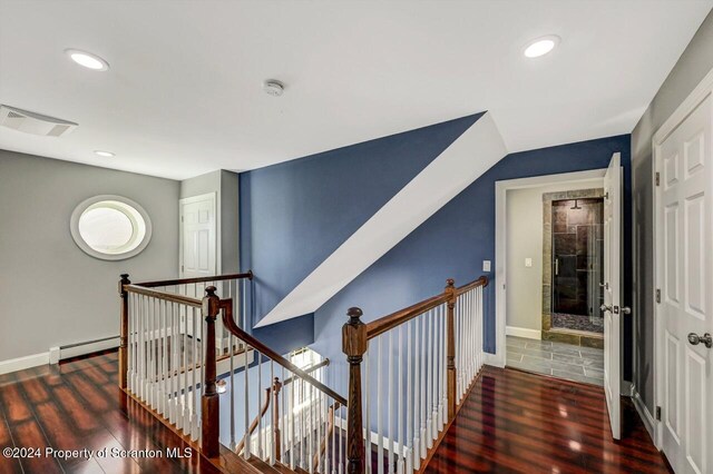 hall featuring dark wood-type flooring and a baseboard heating unit