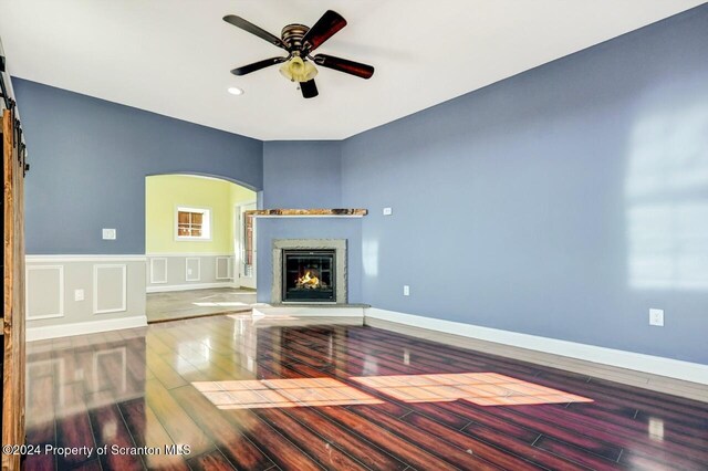 unfurnished living room with ceiling fan and wood-type flooring