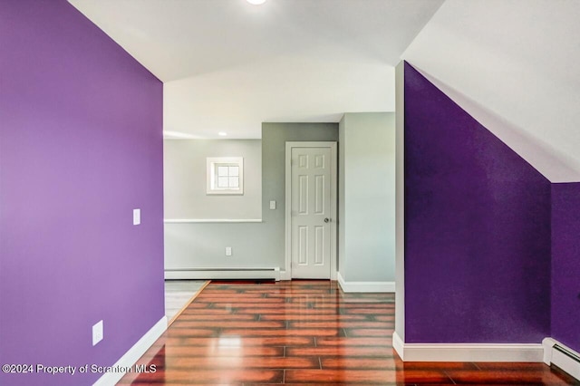 additional living space featuring wood-type flooring and a baseboard heating unit