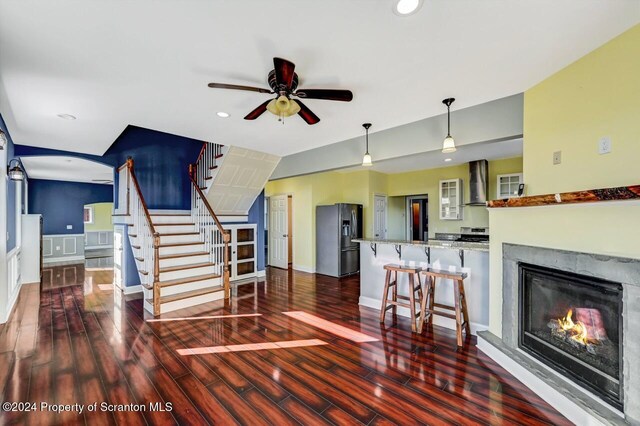 living room with ceiling fan and dark hardwood / wood-style flooring