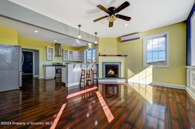 living room with dark hardwood / wood-style floors, a wall unit AC, and ceiling fan