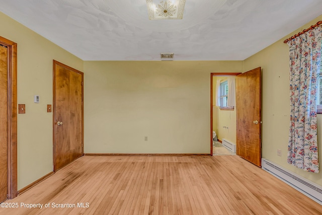 512 Thomas Dr, Dunmore, PA 18512 - spare room with a baseboard heating unit, light wood-type flooring, and baseboard heating