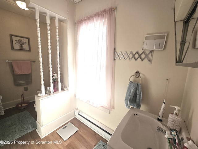 bathroom featuring a baseboard heating unit and wood-type flooring