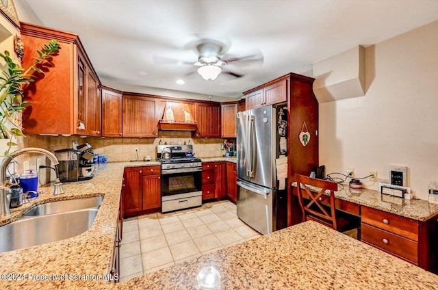 kitchen featuring tasteful backsplash, light stone counters, sink, and appliances with stainless steel finishes