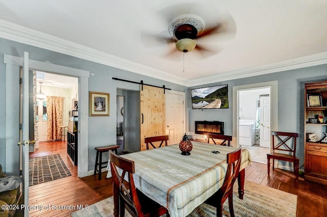 dining space with washer / dryer, a barn door, ceiling fan, and ornamental molding