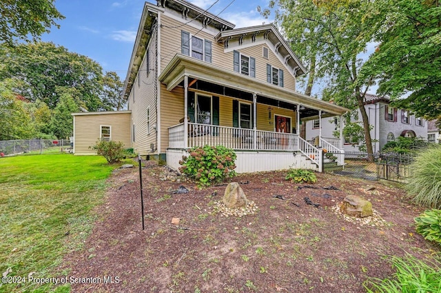 italianate-style house with a porch and a front lawn