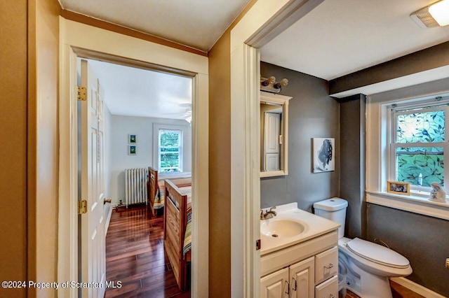 bathroom with radiator heating unit, vanity, toilet, and wood-type flooring