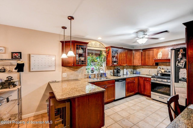 kitchen with kitchen peninsula, appliances with stainless steel finishes, a breakfast bar, sink, and decorative light fixtures