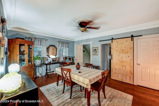 dining area with a barn door, dark wood-type flooring, and crown molding