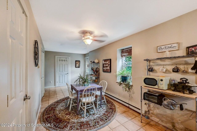 tiled dining room featuring a baseboard radiator and ceiling fan