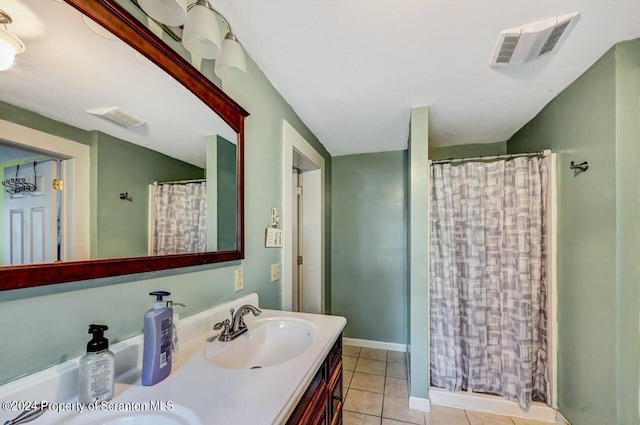 bathroom featuring tile patterned flooring, vanity, and walk in shower