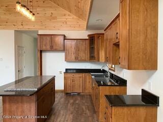 kitchen with dark hardwood / wood-style flooring, a center island, lofted ceiling, and sink