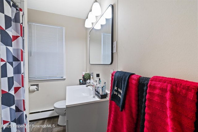 bathroom with hardwood / wood-style flooring, a baseboard radiator, vanity, and toilet