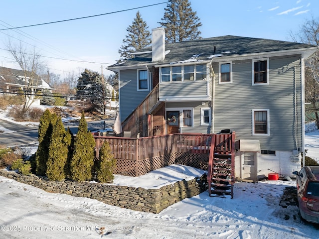 snow covered property featuring a wooden deck