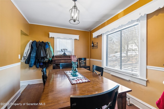 dining area featuring ornamental molding, hardwood / wood-style floors, and a notable chandelier