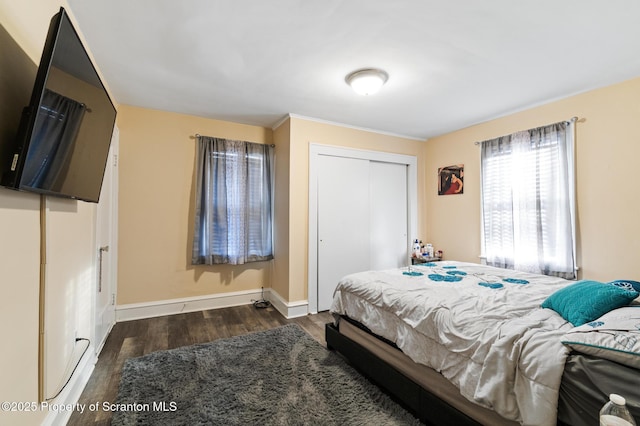 bedroom with dark hardwood / wood-style flooring and a closet