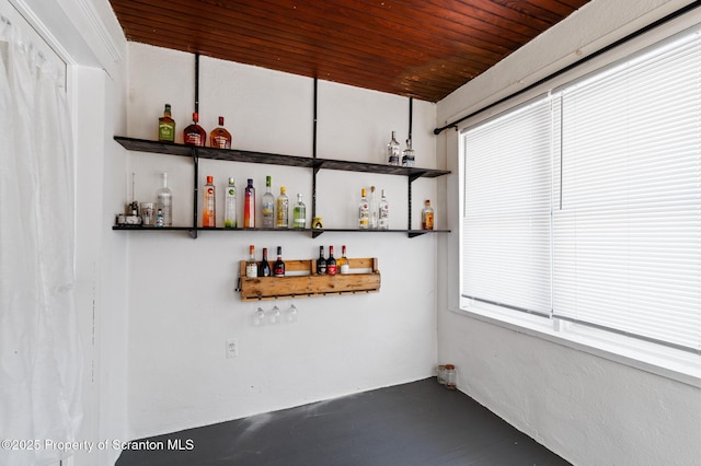 bar with wood ceiling and concrete flooring