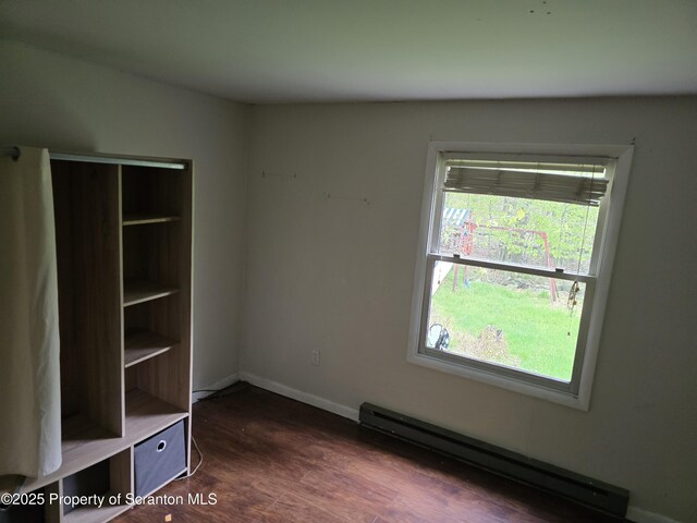1563 Black Birch Way, Tobyhanna, PA 18466 - unfurnished bedroom featuring a baseboard heating unit, dark wood-style flooring, and baseboards