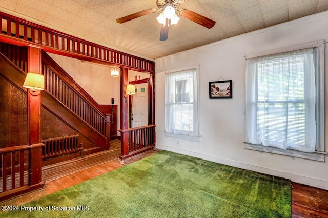 foyer entrance with ceiling fan, radiator heating unit, hardwood / wood-style flooring, and ornamental molding