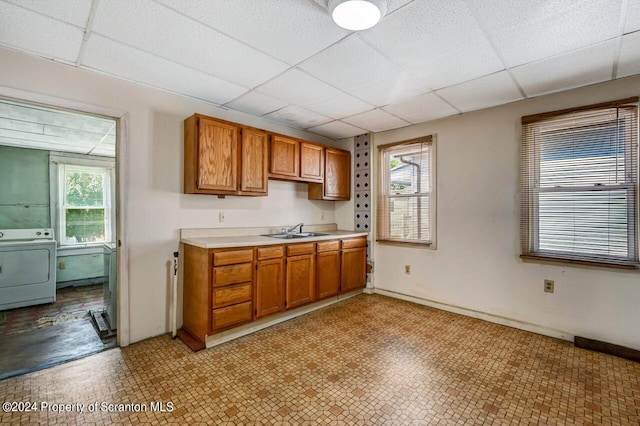 kitchen with a paneled ceiling, washer / clothes dryer, and sink