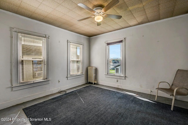 spare room featuring ceiling fan, radiator heating unit, and ornamental molding