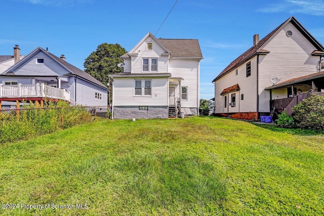 rear view of house featuring a lawn