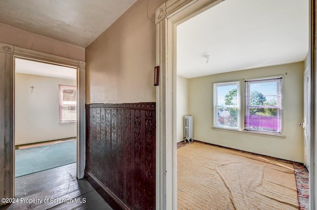 corridor featuring wood-type flooring and radiator