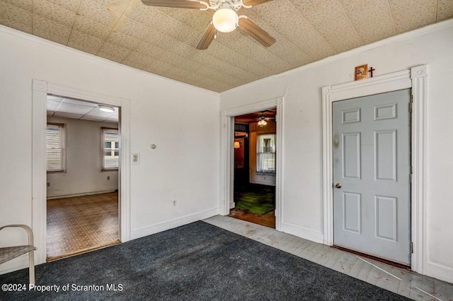 unfurnished bedroom featuring carpet flooring, ceiling fan, and crown molding