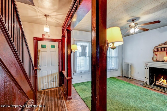 entryway with ceiling fan, radiator heating unit, and hardwood / wood-style flooring