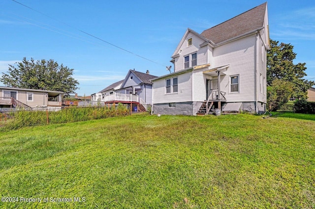 rear view of property featuring a lawn