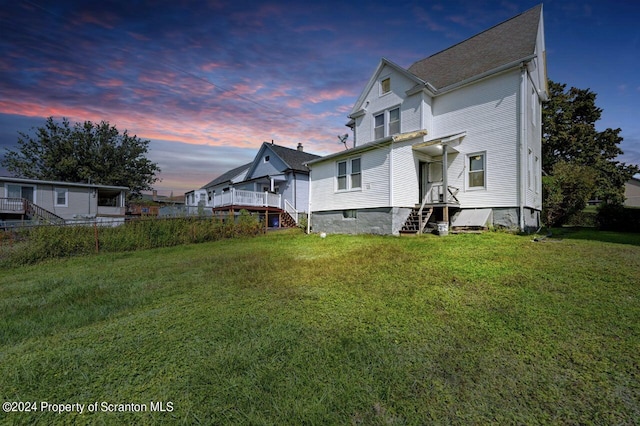 back house at dusk with a yard