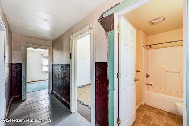 hall with tile patterned floors