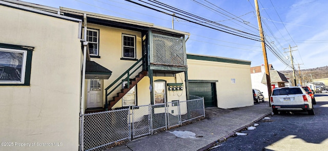 view of front of property featuring stairs and fence